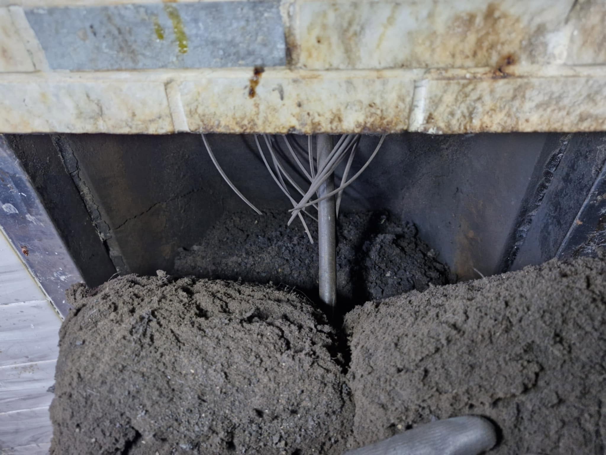 A fall of soot and nest debris in a fireplace with sweeping rods coming down