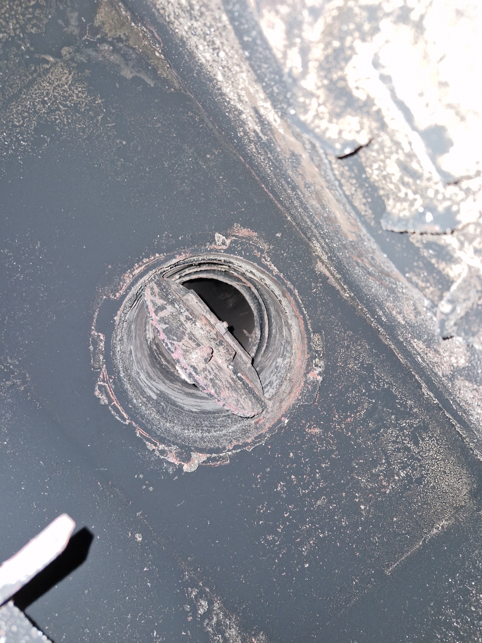 Looking up at a stove's flue collar from inside the firebox