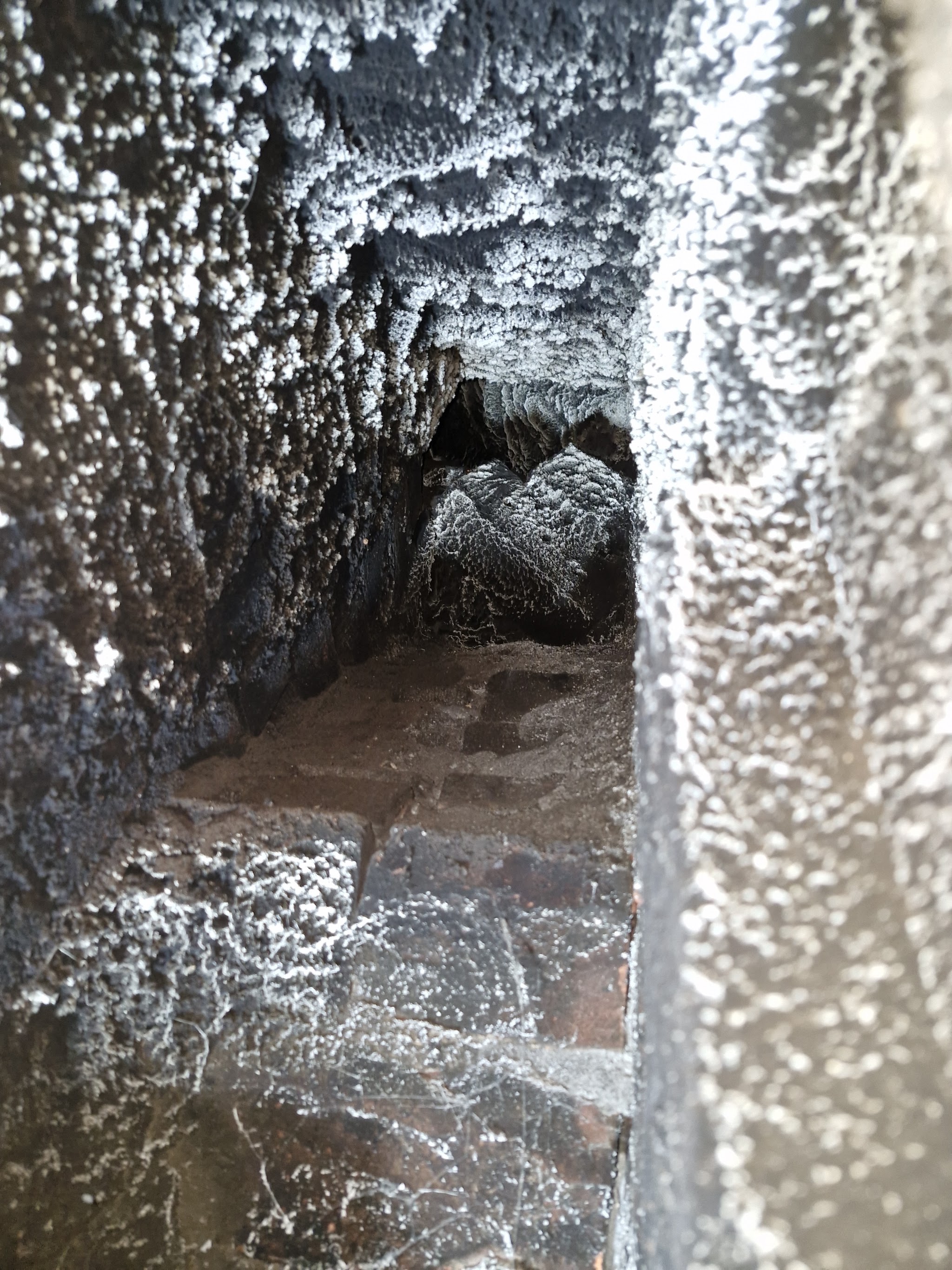 Heavy crusted soot inside a brick flue