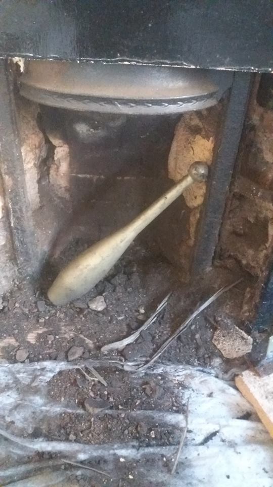 Debris and an old wooden club pulled out of a fireplace opening